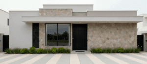 Fachada moderna de vivienda remodelada por Sabaya con líneas rectas donde la albardilla forma parte del diseño superior de los volúmenes arquitectónicos